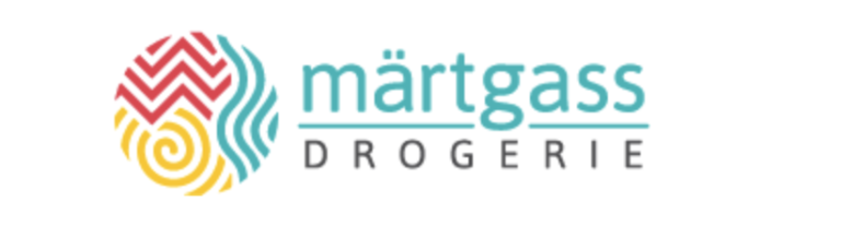 Das Logo für „Märtgass Drogerie“ besteht aus farbenfrohen abstrakten Formen – einem roten Zickzack, einer gelben Spirale und blauen Wellenlinien – in einem Kreis, mit dem Firmennamen in blaugrüner und grauer Schrift auf der rechten Seite, was ein Gefühl von Kreativität und Lebendigkeit vermittelt.