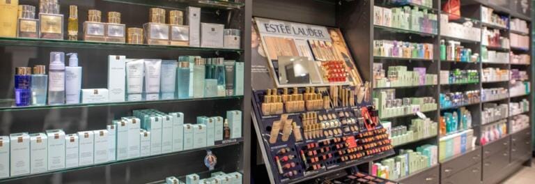In den Regalen der Drogerie Horgen werden verschiedene Hautpflege- und Kosmetikprodukte präsentiert, darunter verpackte Artikel und eine Make-up-Abteilung von Estée Lauder mit Lippenstiften und Pudern sowie ausgewählte Welldro-Essentials.