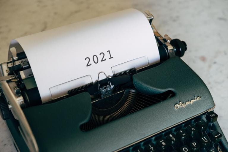 Eine Nahaufnahme einer grünen Olympia-Schreibmaschine in Wädenswil mit einem Blatt Papier, auf dem in fetter, schwarzer Schrift die Jahreszahl 2021 steht.
